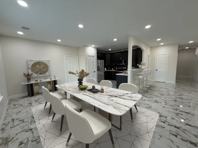 a kitchen with a dining table chairs and view living room