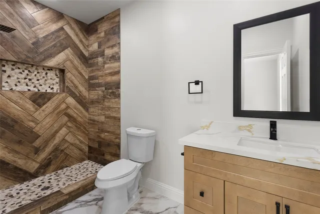 a bathroom with a sink toilet and mirror