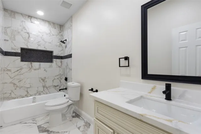a bathroom with a granite countertop sink toilet and shower