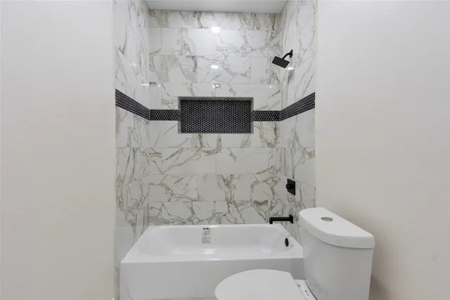 a bathroom with a toilet and a shower