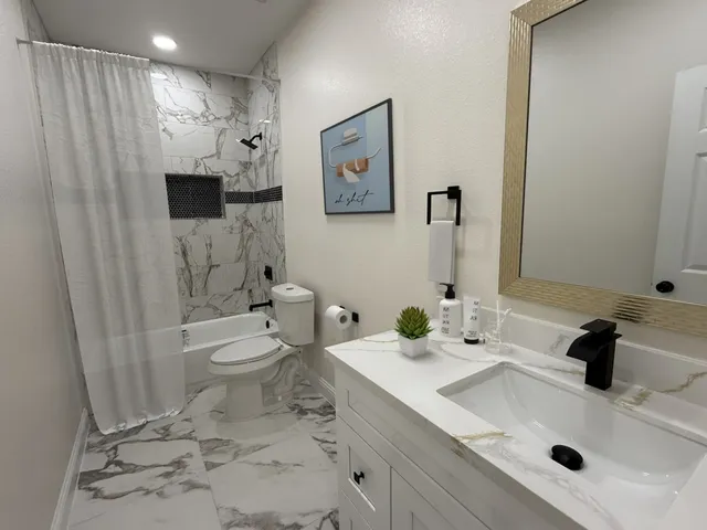 a bathroom with a sink toilet and shower