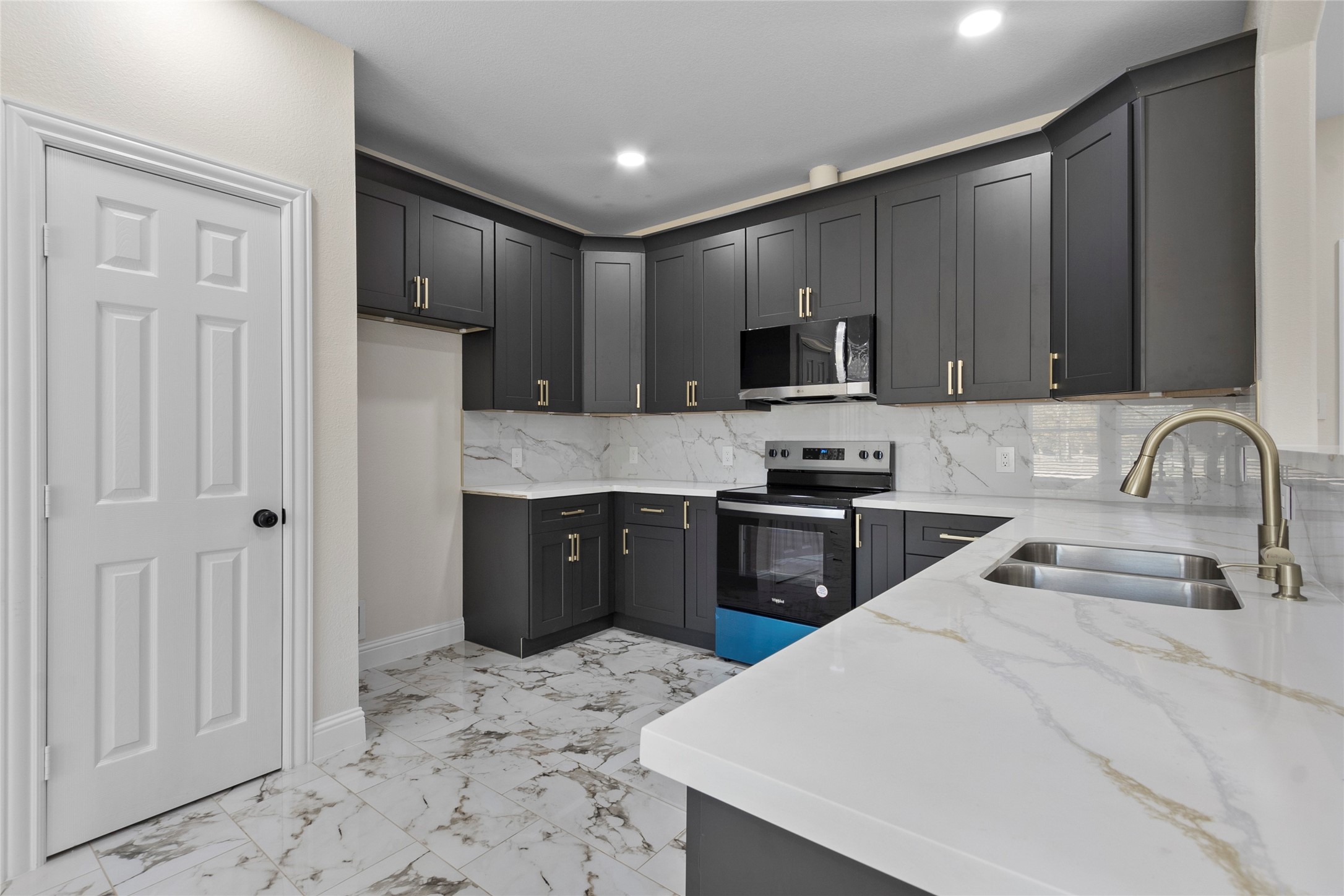 155 County Road 3372 Cleveland, TX 77327 - Photo 34 of 36 a kitchen with granite countertop a refrigerator stove top oven and sink