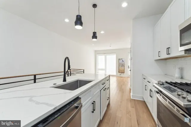 a kitchen with stainless steel appliances a sink stove and cabinets