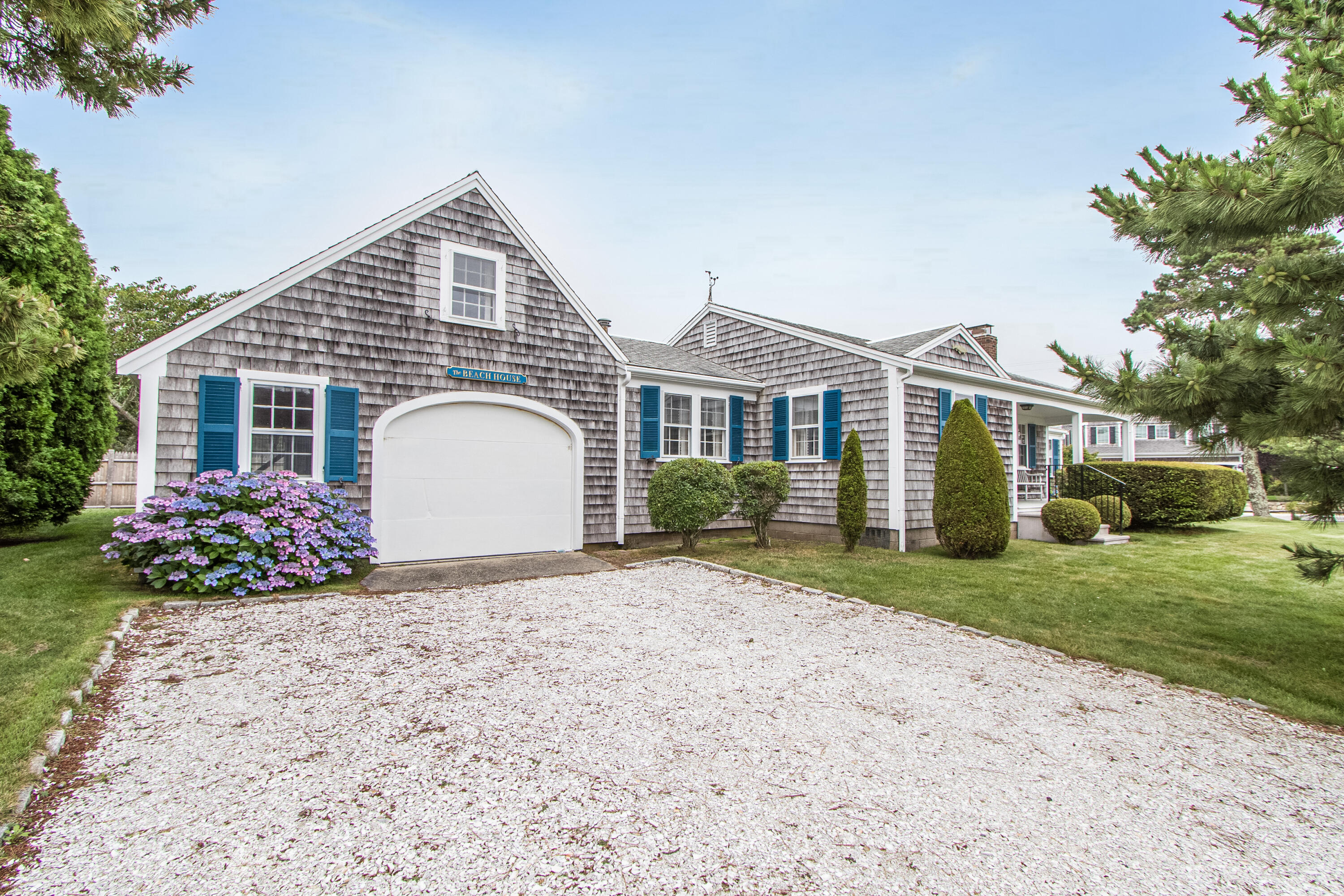 92 Surfside Road West Dennis, MA 02670 - Photo 4 of 38 a front view of a house with a garden and trees