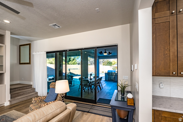 1283 North Gallen Road Santa Clara, UT 84765 - Photo 18 of 103 Living area featuring built in shelves, a textured ceiling, light wood-style flooring, a ceiling fan, and healthy amount of natural light