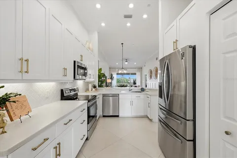 a kitchen with stainless steel appliances a refrigerator sink and microwave
