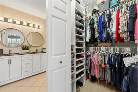 a view of walk in closet with clothes and shoes