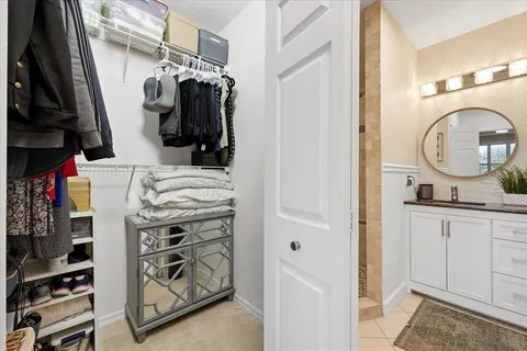 a view of walk in closet with clothes and shoes