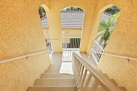 a view of staircase with railing and white walls