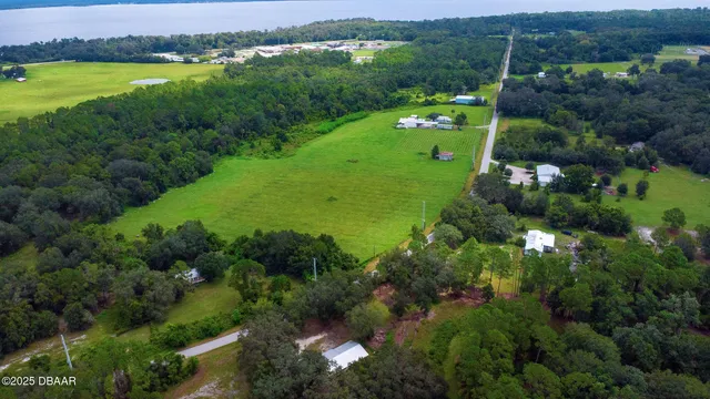 an aerial view of green landscape with trees houses and mountain view