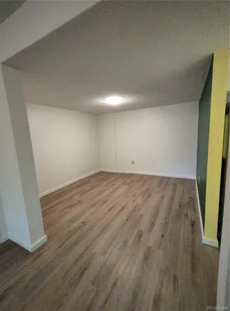 an empty room with wooden floor and mirror