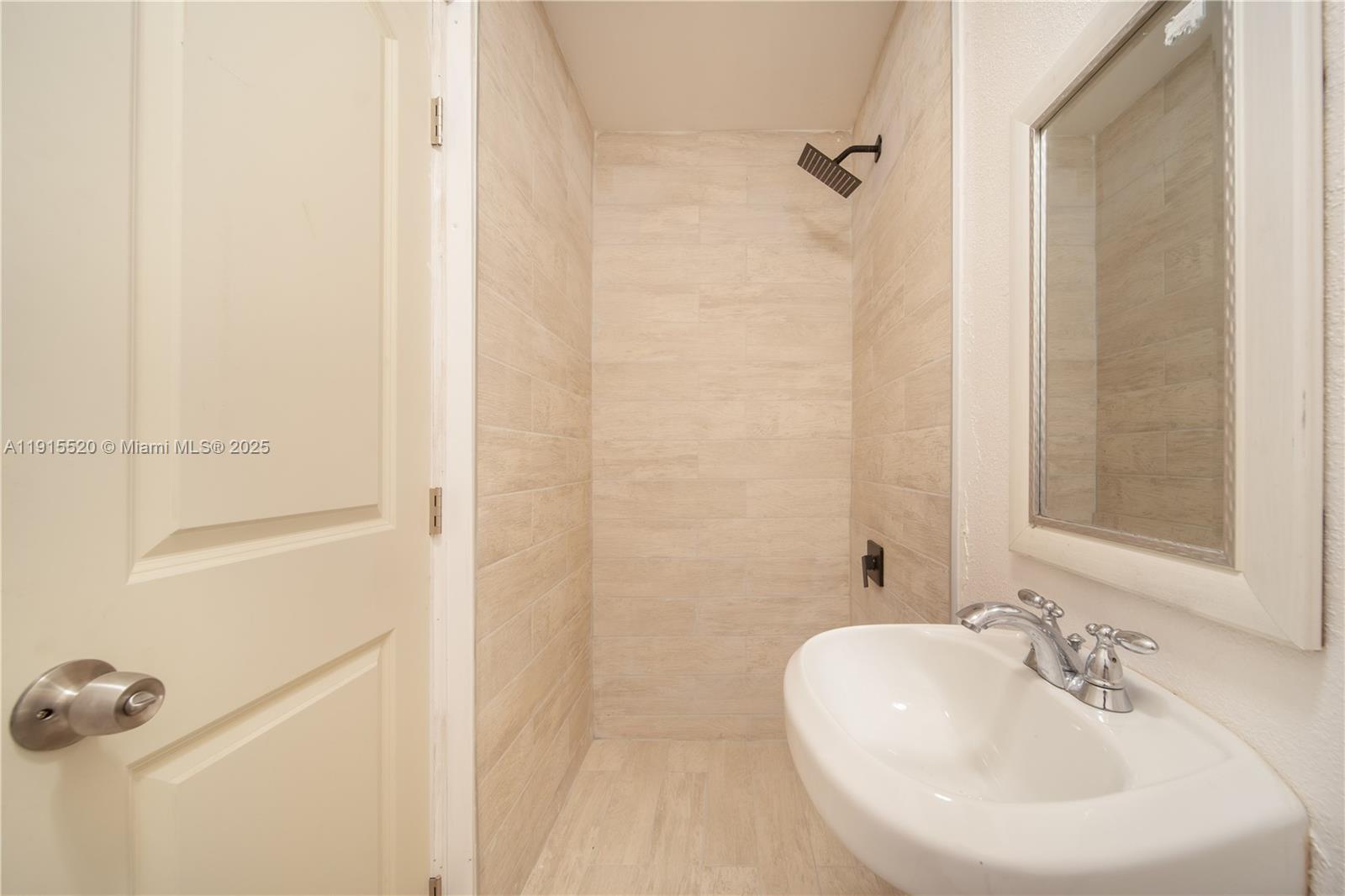 435 Southwest 33rd Avenue, Unit 4 Miami, FL 33135 - Photo 11 of 22 a bathroom with a sink a mirror and shower