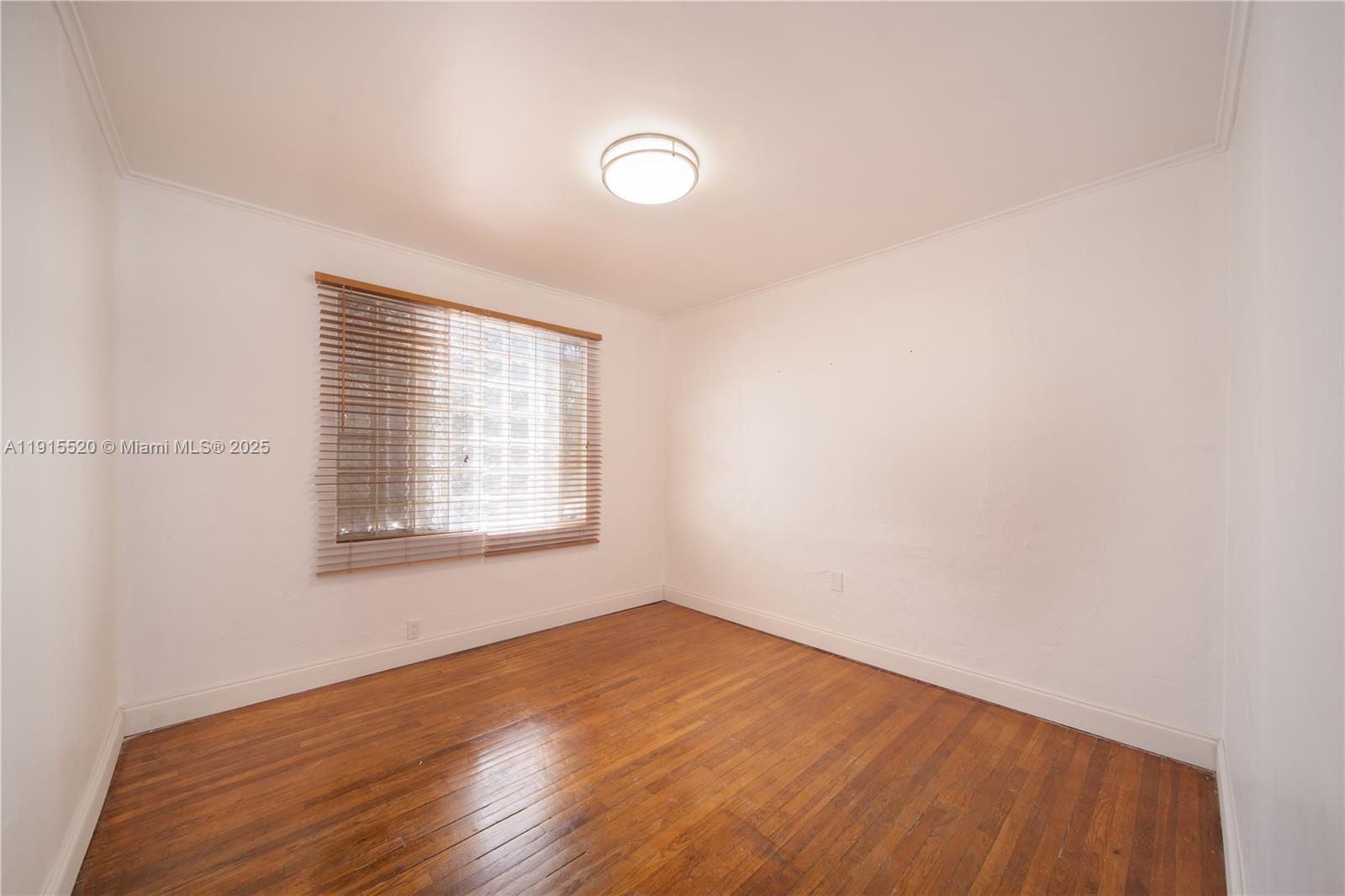 435 Southwest 33rd Avenue, Unit 4 Miami, FL 33135 - Photo 16 of 22 an empty room with wooden floor and windows