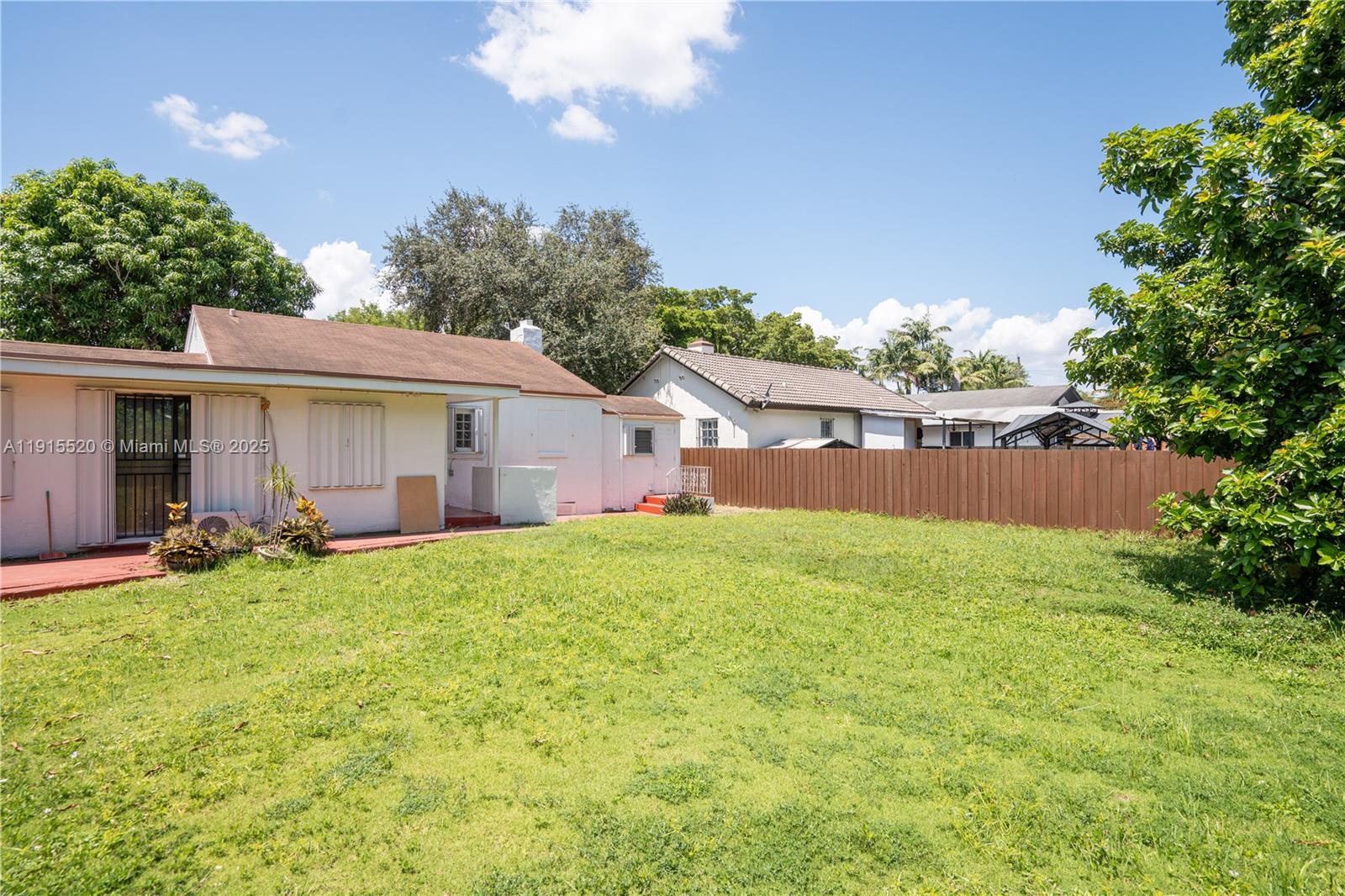 435 Southwest 33rd Avenue, Unit 4 Miami, FL 33135 - Photo 21 of 22 a backyard of a house with table and chairs plants and large tree