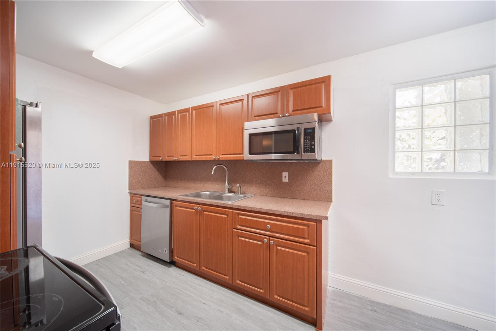 435 Southwest 33rd Avenue, Unit 4 Miami, FL 33135 - Photo 3 of 22 a kitchen with stainless steel appliances granite countertop a sink stove and microwave