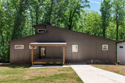 a backyard of a house with large trees and a barn