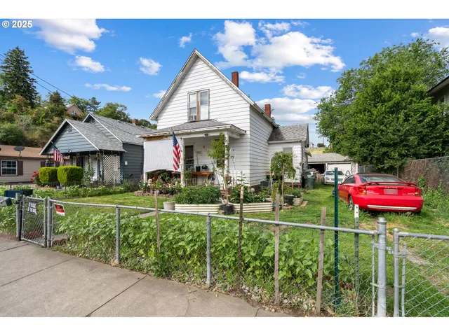 a front view of a house with a yard and potted plants