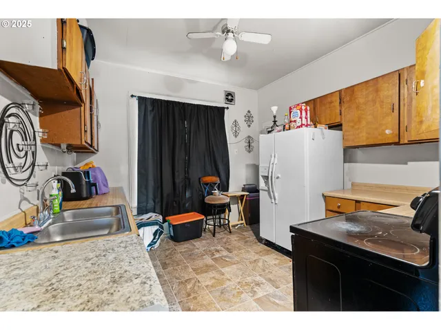 a living room with furniture and a refrigerator