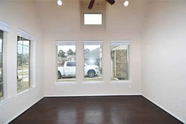 an empty room with wooden floor and windows