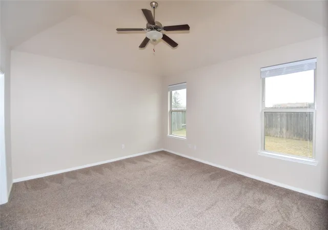 an empty room with a window and a fan