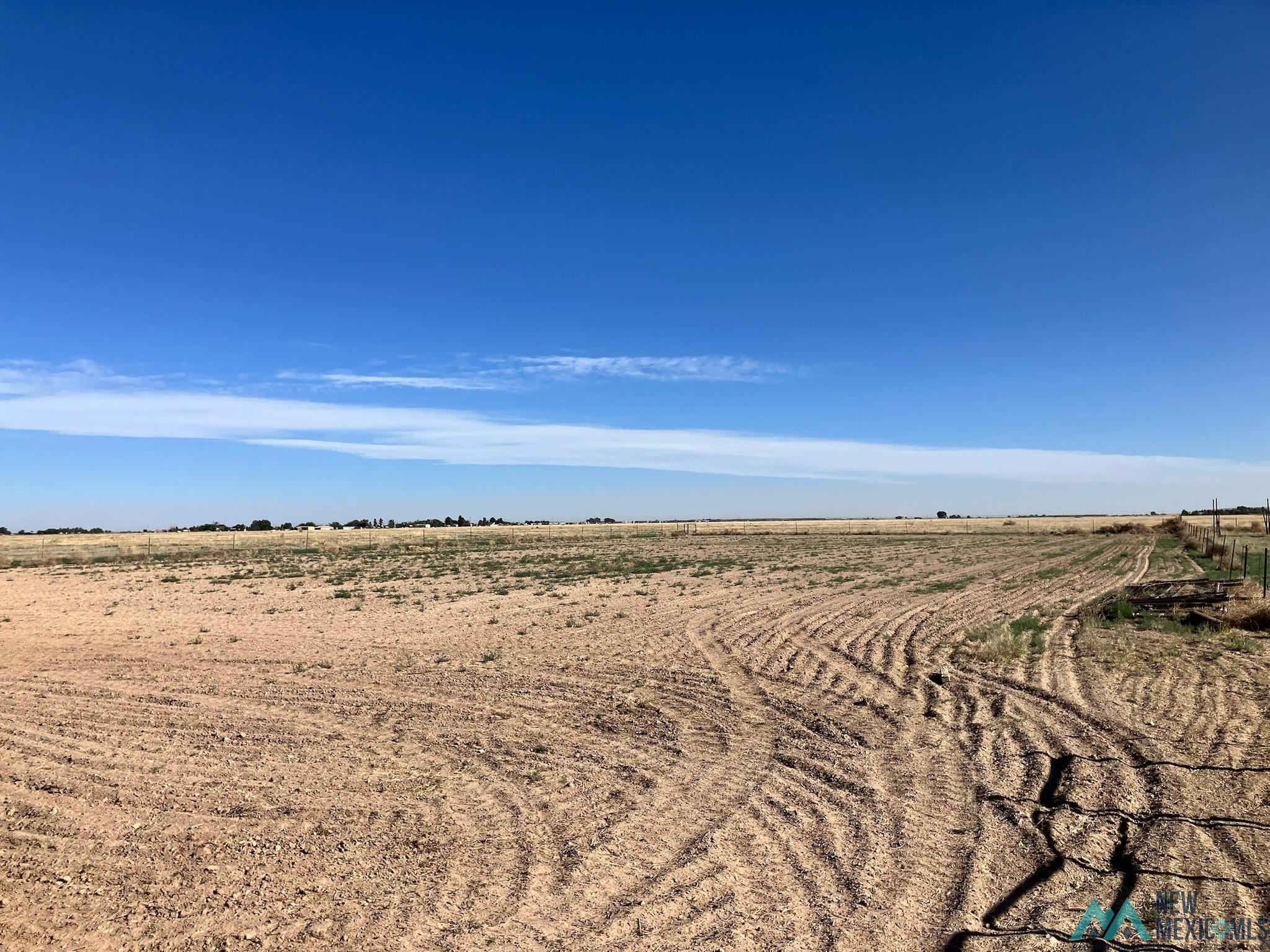 6660 Cherokee Road Dexter, NM 88230 - Photo 42 of 46 Expansive open land with visible tilling patterns under a broad blue sky