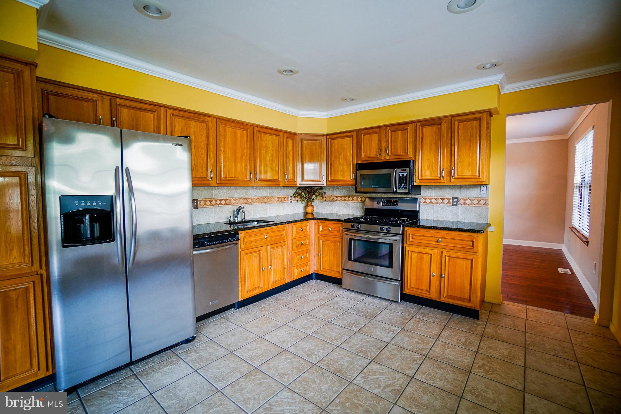 12 Blue Grass Road Clementon, NJ 08021 - Photo 8 of 23 a kitchen with granite countertop stainless steel appliances and wooden cabinets