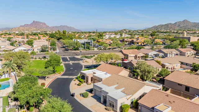 an aerial view of a city with lots of residential buildings and mountain view in back