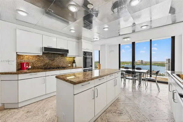 a kitchen with stainless steel appliances granite countertop a sink a stove and cabinets