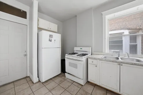 a kitchen with white cabinets and white appliances