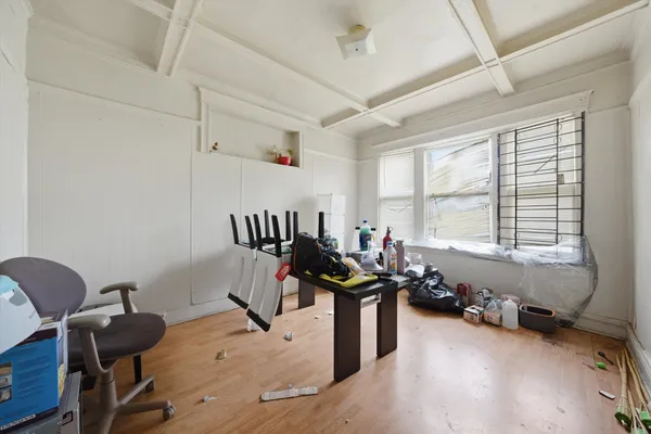 a view of an empty room with a window and wooden floor