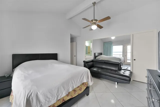 a spacious bedroom with a bed and a chandelier