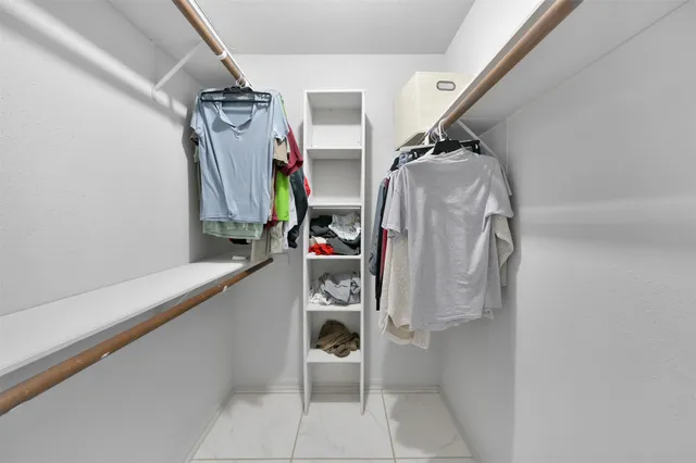 a view of walk in closet with clothes and shoes
