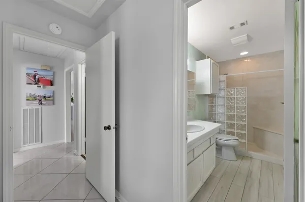 a bathroom with a toilet a sink a shower and a mirror