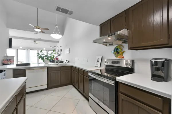 a kitchen with kitchen island granite countertop stainless steel appliances lots of counter space sink and stove