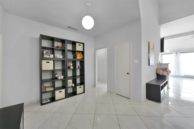 a view of an empty room with cabinet and a window