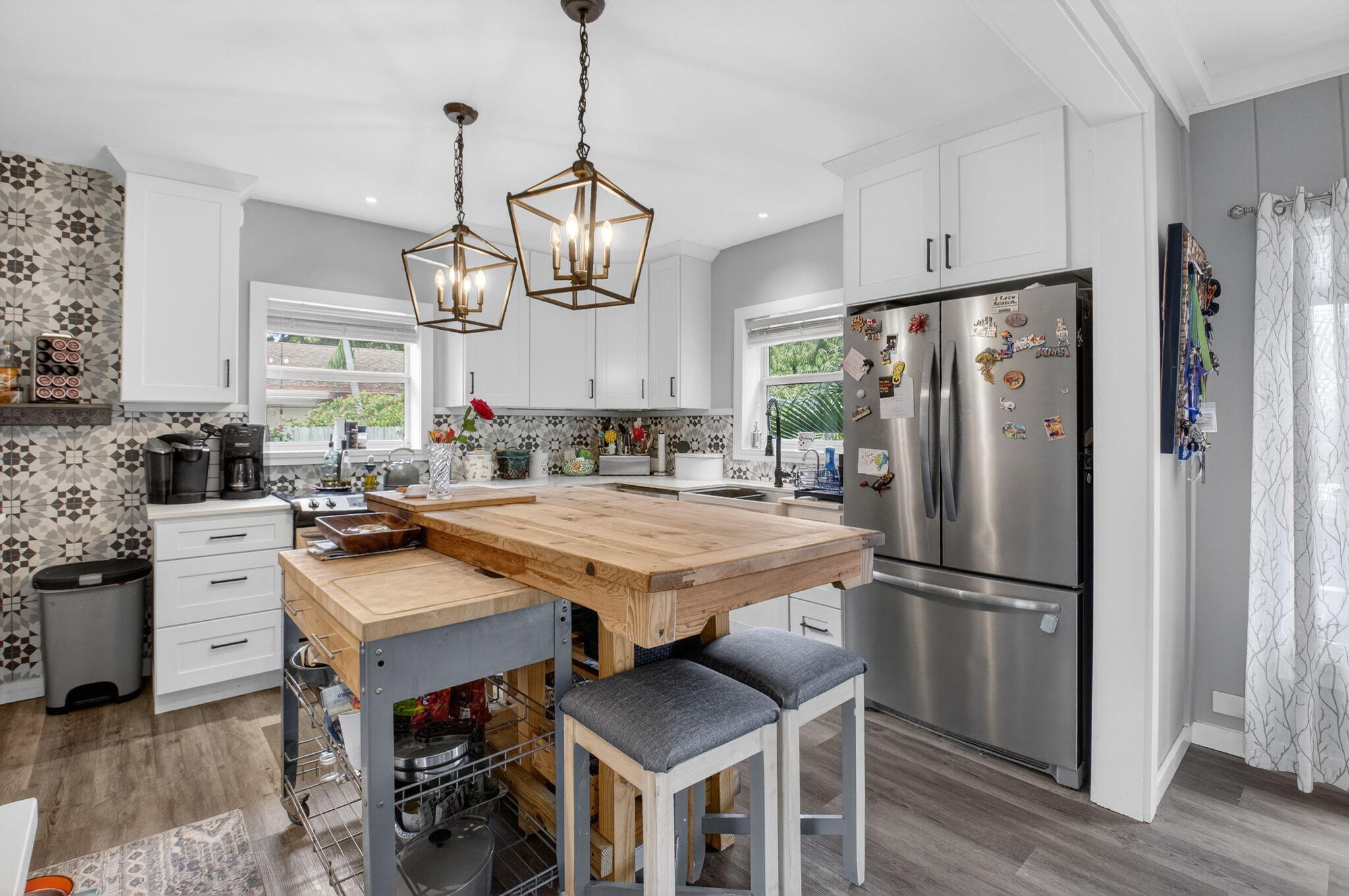 233 Northeast 12th Street Delray Beach, FL 33444 - Photo 29 of 55 a kitchen with stainless steel appliances a table chairs and refrigerator