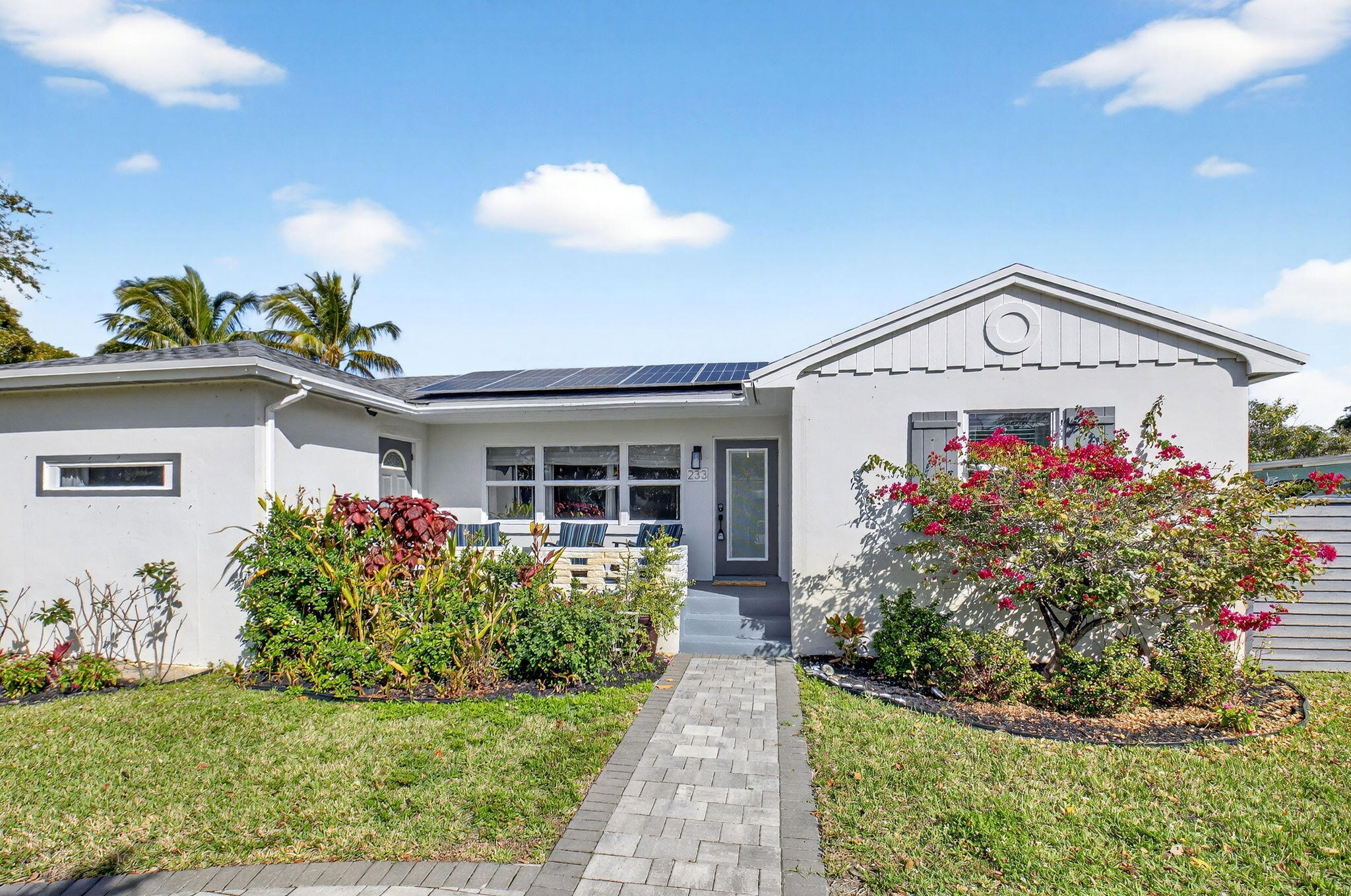 233 Northeast 12th Street Delray Beach, FL 33444 - Photo 3 of 55 a front view of a house with a yard and potted plants