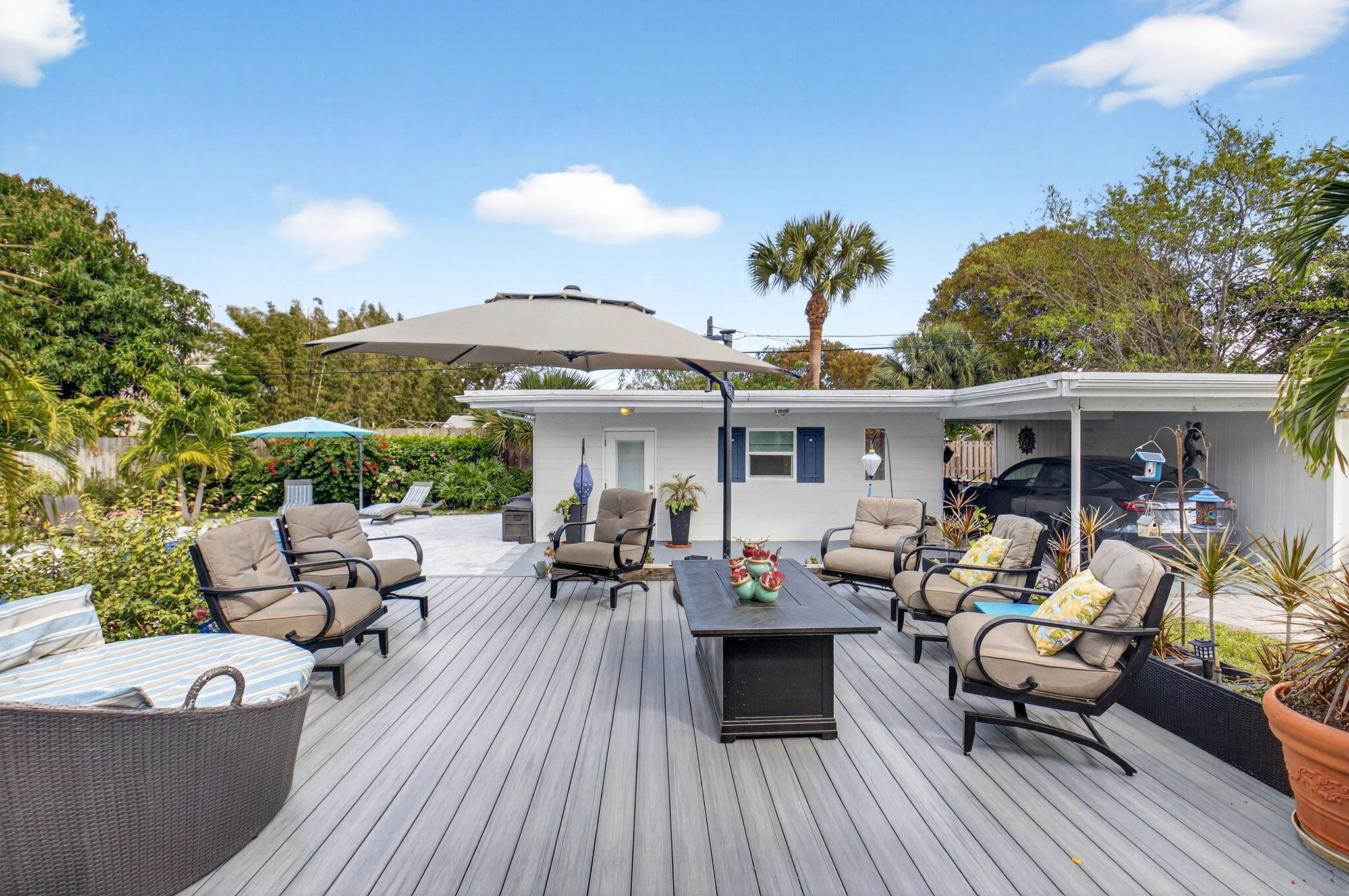 233 Northeast 12th Street Delray Beach, FL 33444 - Photo 39 of 55 a view of a patio with couches table and chairs under an umbrella with wooden floor