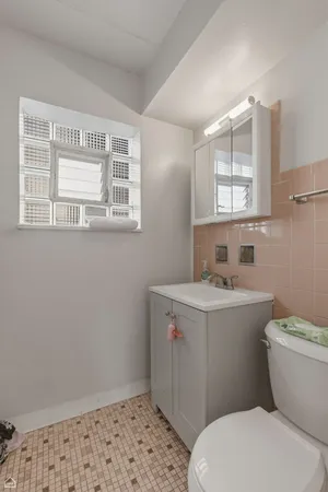 a bathroom with a sink a toilet and a window