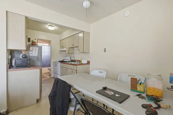 a kitchen with a table chairs refrigerator and cabinets