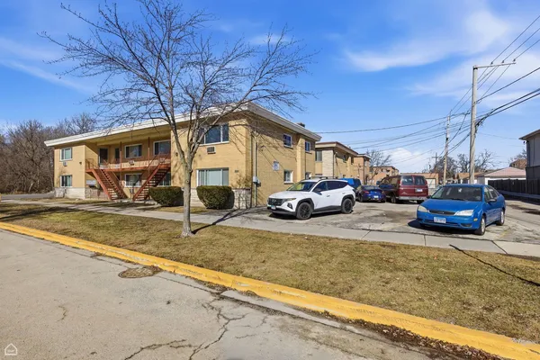 a view of a house with cars parked
