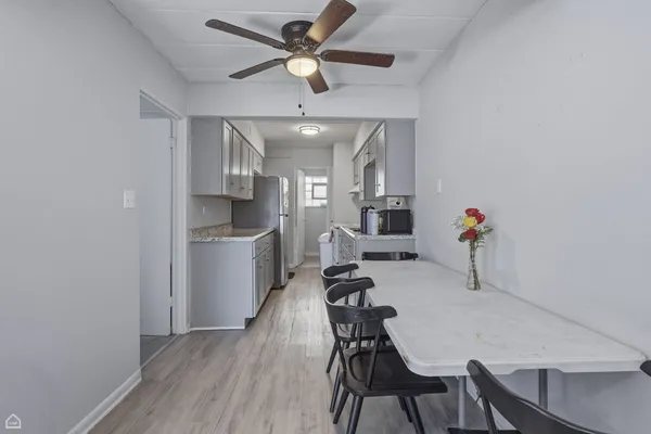 a view of a dining room with furniture and a chandelier fan
