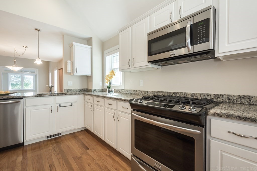 13 Trail Ridge Way, Unit D Harvard, MA 01451 - Photo 16 of 42 a kitchen with cabinets stainless steel appliances and wooden floor