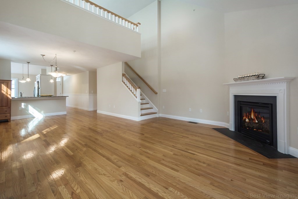 13 Trail Ridge Way, Unit D Harvard, MA 01451 - Photo 5 of 42 a view of a livingroom with wooden floor and a fireplace