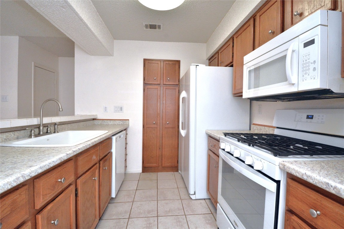3839 Dry Creek Drive, Unit 220 Austin, TX 78731 - Photo 7 of 26 a kitchen with a sink stove and refrigerator