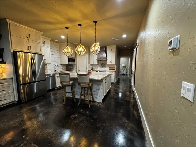 a dining room with stainless steel appliances furniture a rug and a kitchen view