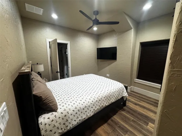 a bedroom with bed and flat screen tv