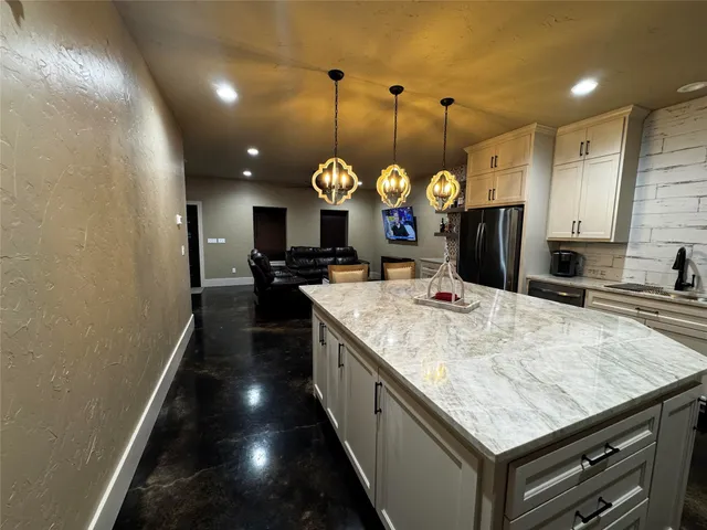 a large kitchen with kitchen island a large island in it
