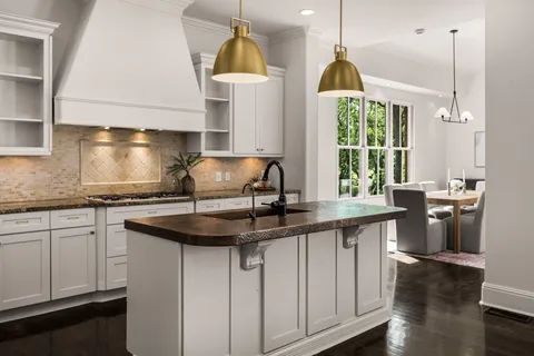 a kitchen with a sink a window and chairs