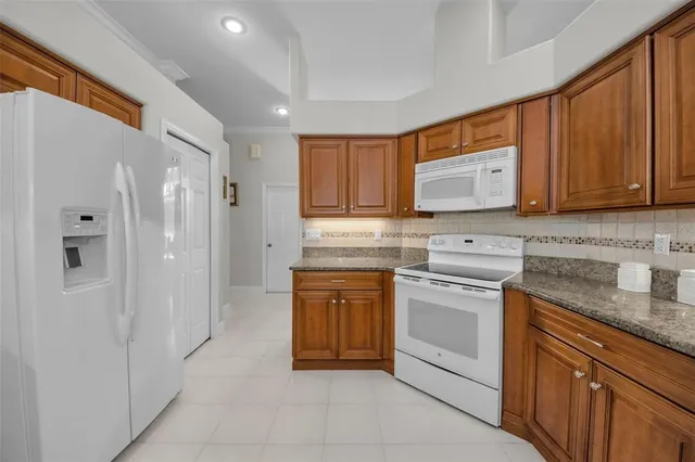 a kitchen with stainless steel appliances granite countertop wooden cabinets and a counter top space